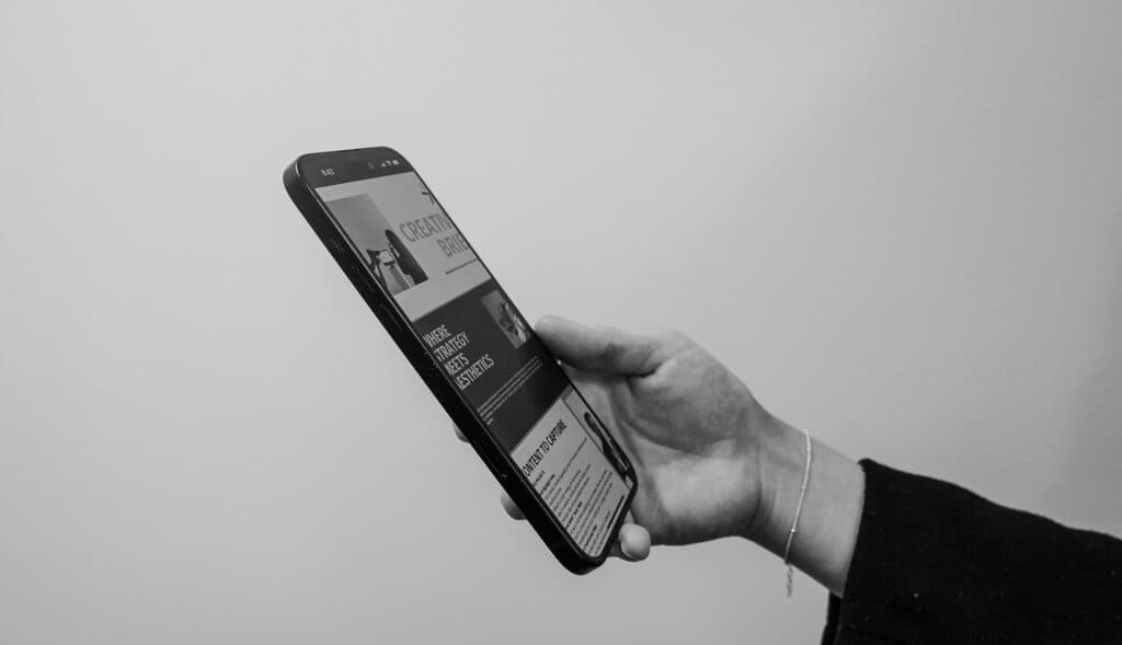 Hand holding a phone, black and white