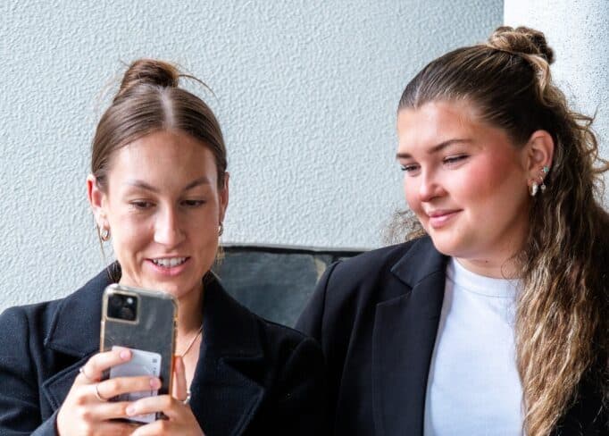 Two Brink team members looking at a phone
